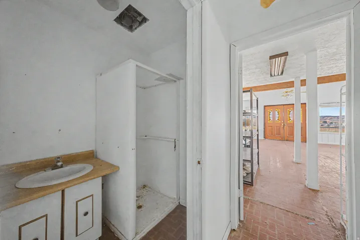 Bathroom area featuring a built-in shower stall and a vanity with an oval sink