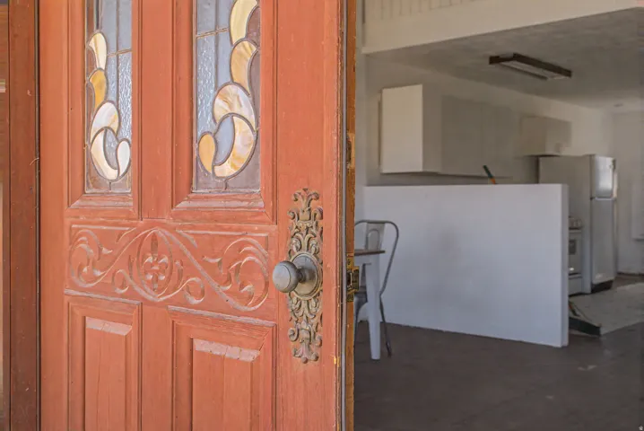 Wood-paneled entry door with decorative glass inserts and ornate hardware