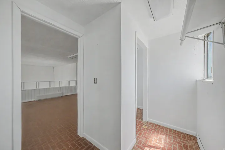 Interior space featuring brick-patterned flooring and white walls