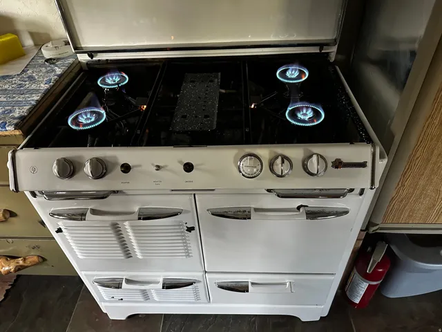 White gas range featuring four burners and integrated oven compartments