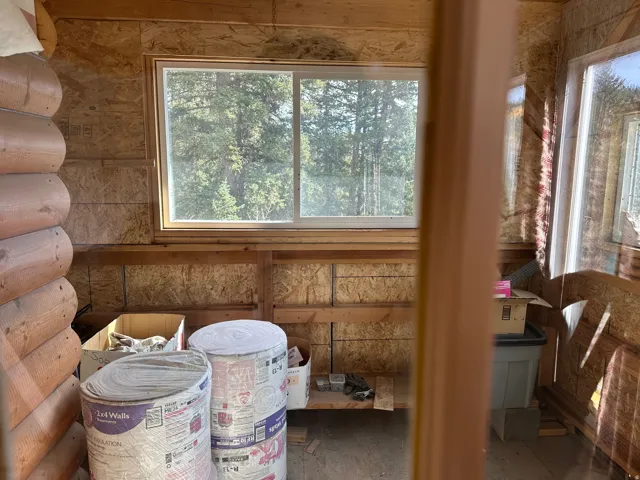 Interior space featuring a dual-pane window and exposed wood framing