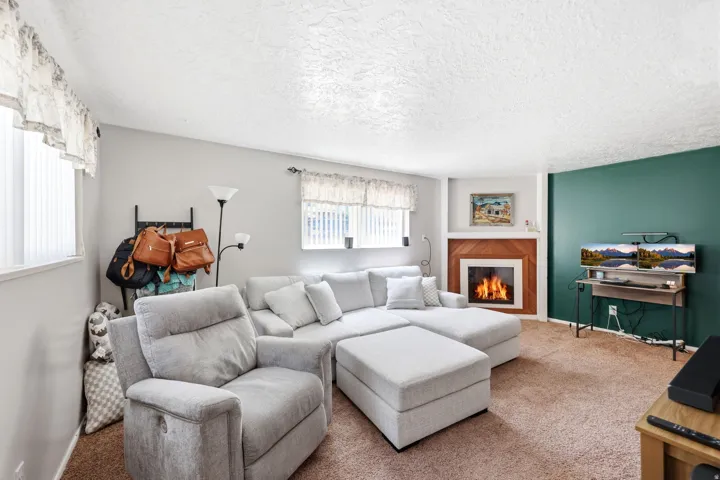 Living area featuring a fireplace with wood paneling and a white mantel
