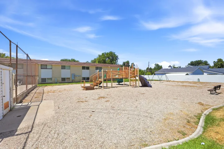 Outdoor recreation area featuring a playground structure with slides and swings
