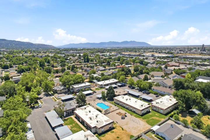 Expansive aerial perspective showcasing a residential neighborhood with surrounding mountains