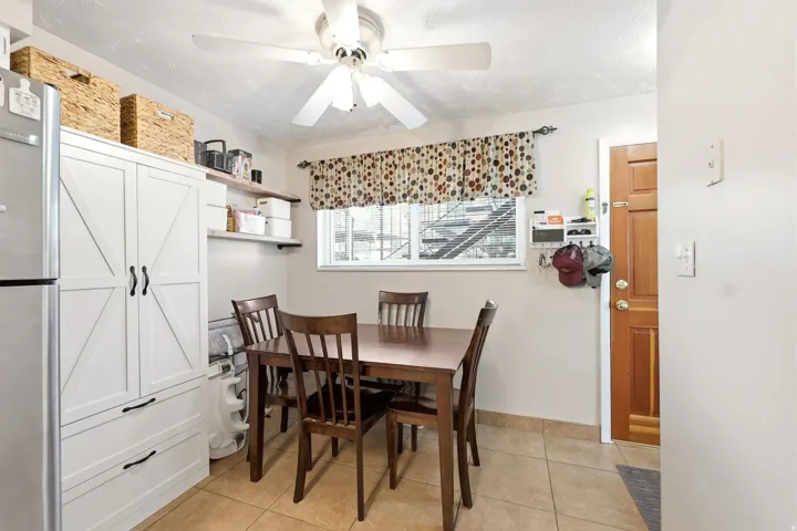 Dining area featuring a wood-finish table, tile flooring, and a ceiling fan