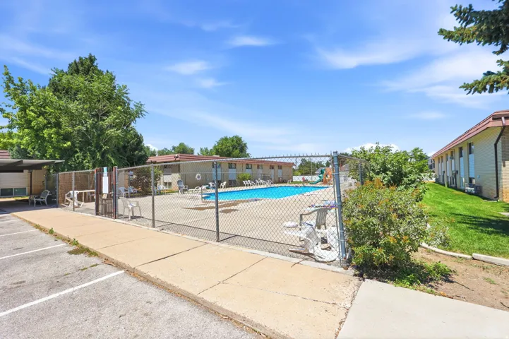 Outdoor swimming pool area featuring a chain-link fence enclosure