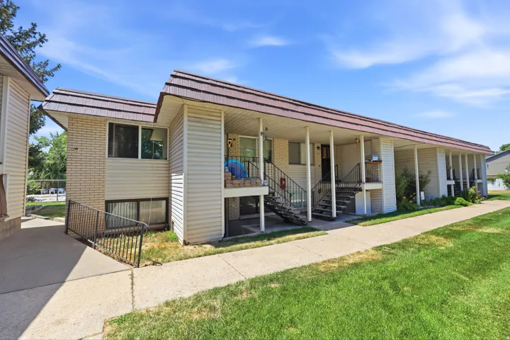 Multi-unit property featuring a brown metal roof and light-colored siding