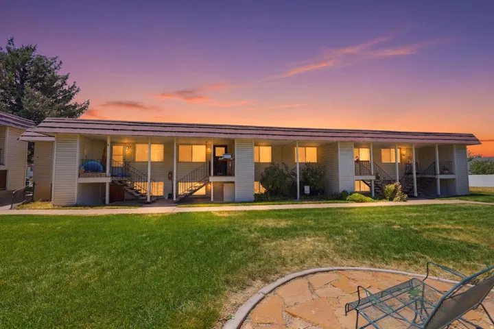 Multi-unit building featuring exterior siding, individual balconies, and ground-level patios