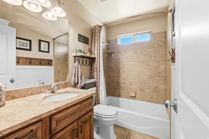 Bathroom featuring a vanity with a light-toned countertop, a single basin sink, and wood-finish cabinetry
