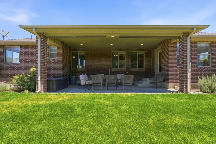 Expansive covered patio featuring brick exterior walls and recessed lighting