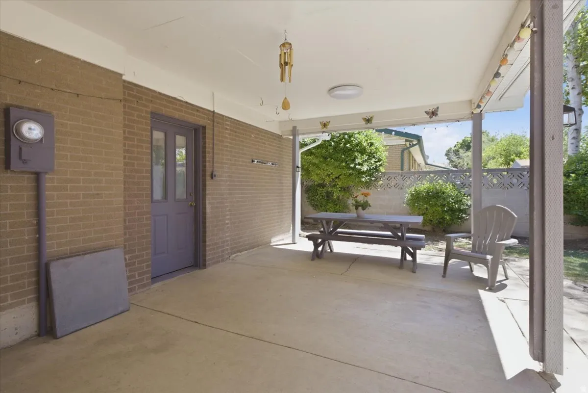 Covered patio featuring a concrete slab and brick exterior wall
