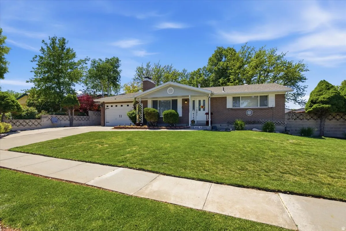 Brick exterior with a covered entry and a concrete driveway