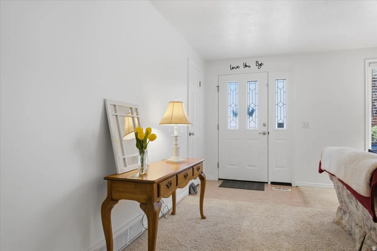 Front entry featuring a white door with three decorative glass panels, flanked by a coordinating sidelight