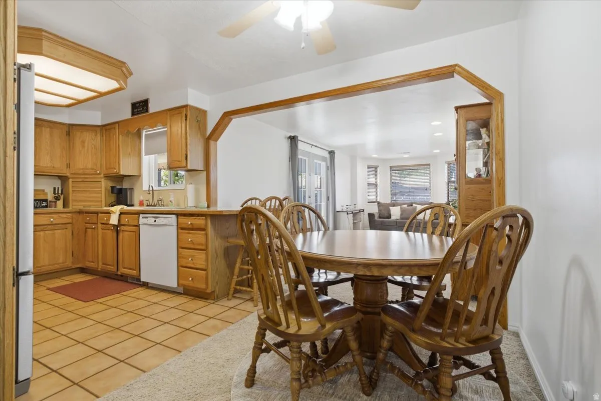 Kitchen featuring wood cabinetry, tile flooring, and a pass-through opening to an additional room