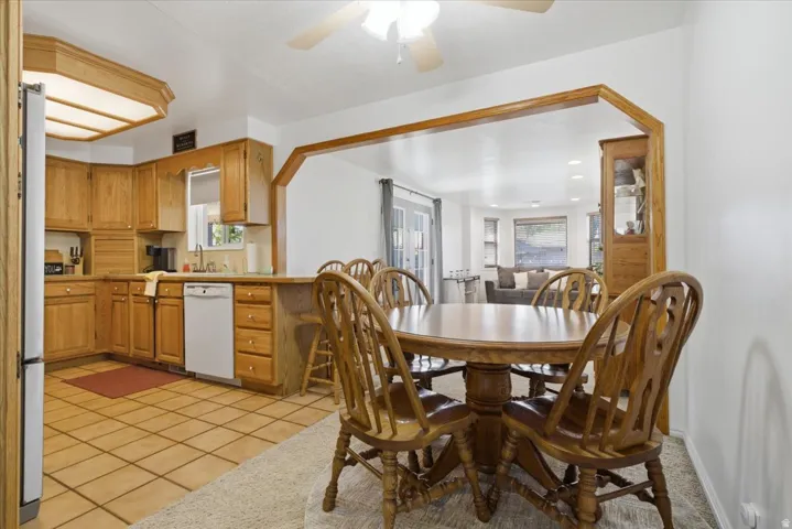 Kitchen featuring wood cabinetry, tile flooring, and a pass-through opening to an additional room