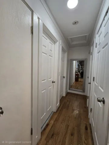 Hallway featuring wood-finish flooring, white paneled doors, and recessed lighting