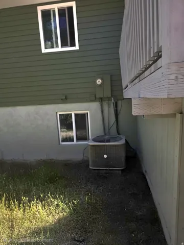 Exterior features include horizontal siding, a stucco foundation, and a white-framed window