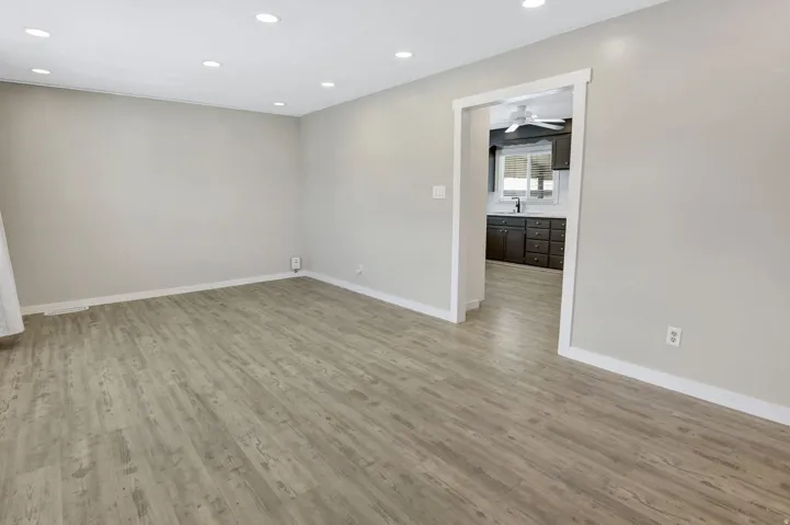 Open-concept living area with recessed lighting, light wood-finish flooring, and a neutral color palette