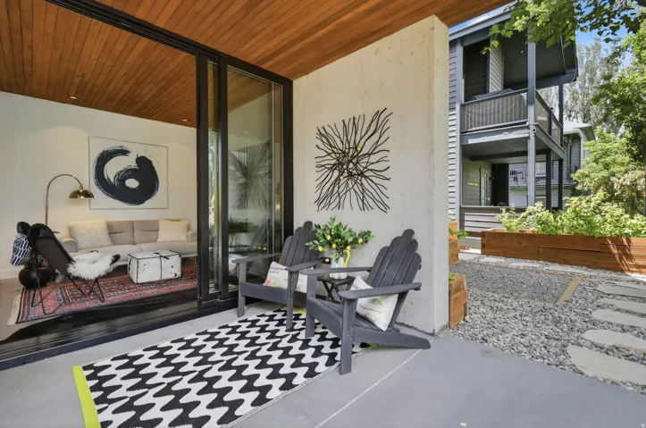 Concrete patio with two Adirondack chairs, a gravel ground covering, and raised planter boxes
