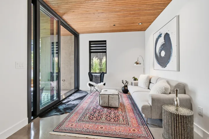 Spacious room with a wood-plank ceiling, concrete flooring, and white walls