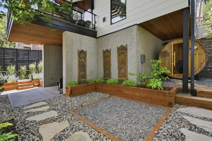 Exterior concrete wall featuring decorative panels and a barrel-style sauna