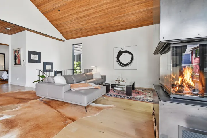 Vaulted wood-paneled ceiling above a living area featuring light wood-finish flooring