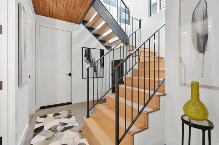 Open-tread staircase with natural wood steps and black metal railings