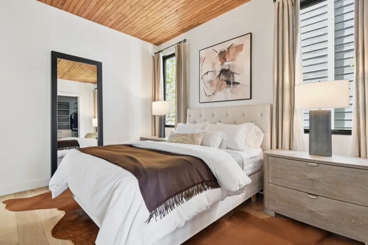 Bedroom featuring a wood-finish plank ceiling, light wood-finish flooring, and white walls