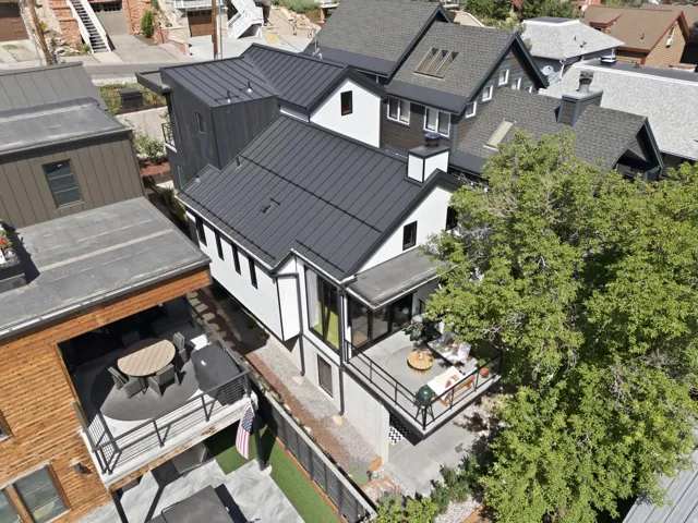 Contemporary exterior with a dark metal standing seam roof and white vertical siding