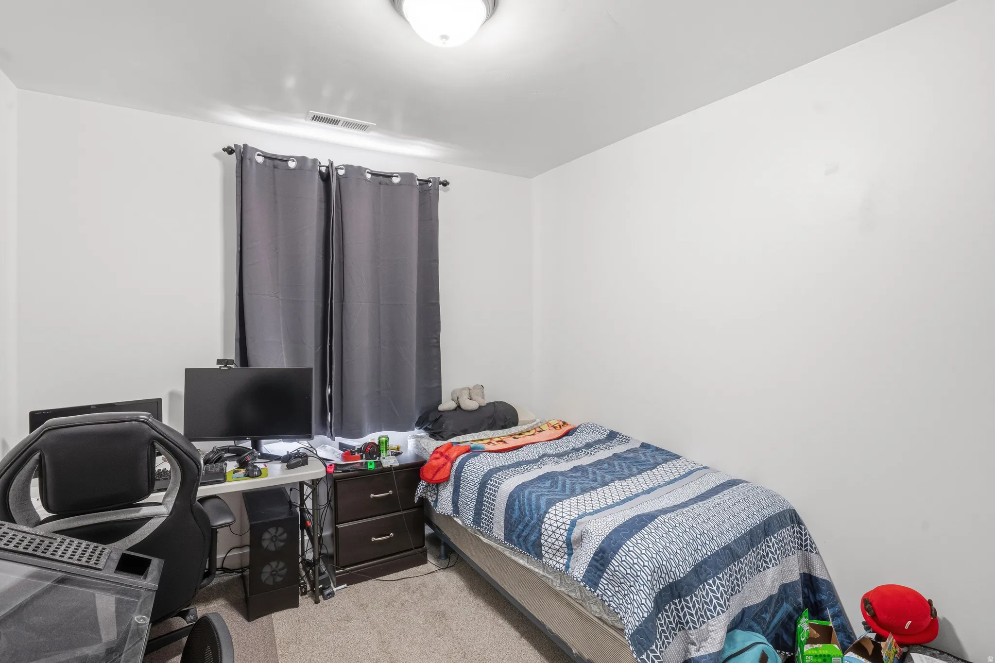Bright room featuring light-colored walls and neutral carpeting