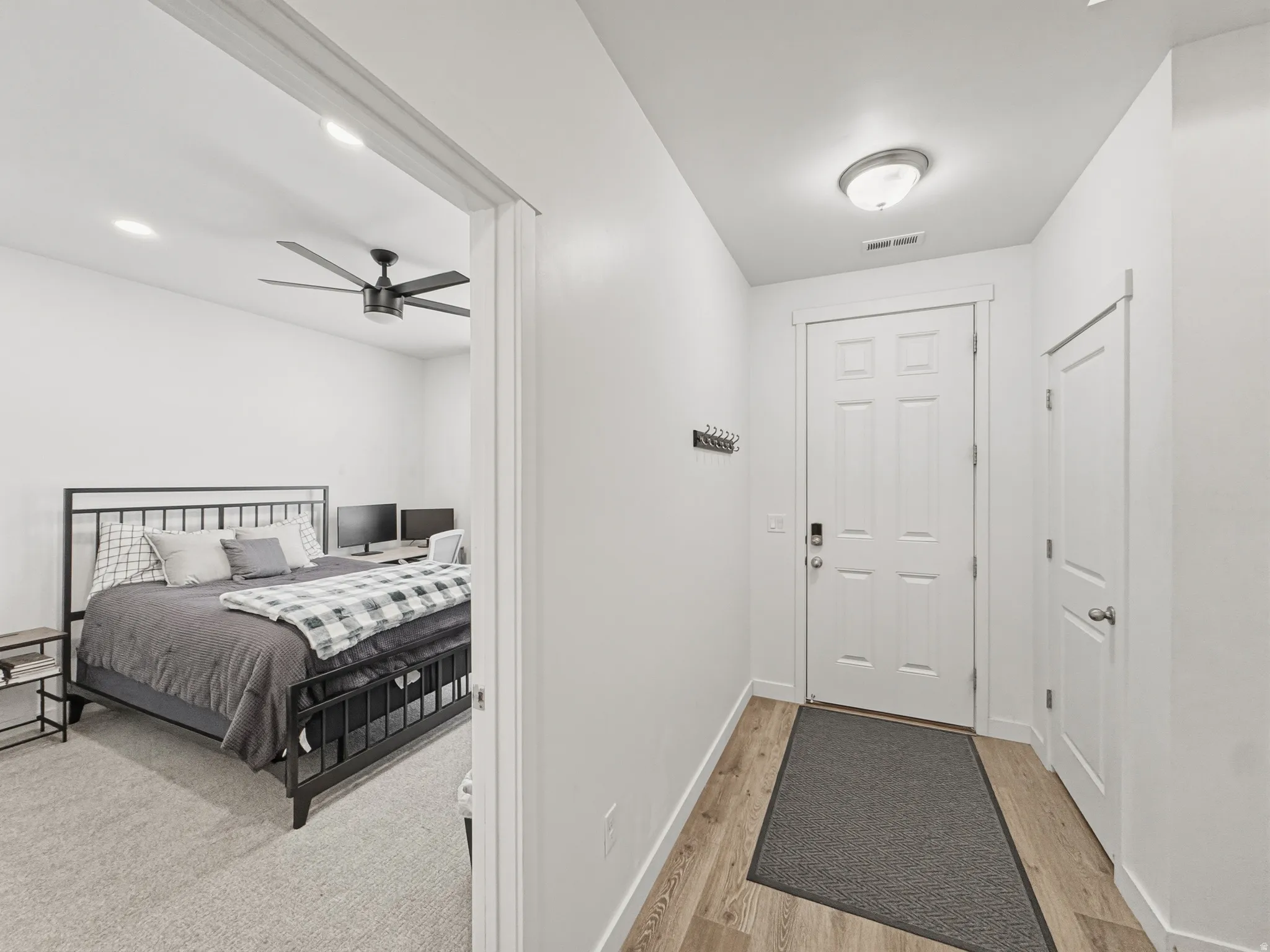 Entryway featuring wood-finish flooring, a white paneled door with modern hardware, and a flush mount ceiling light