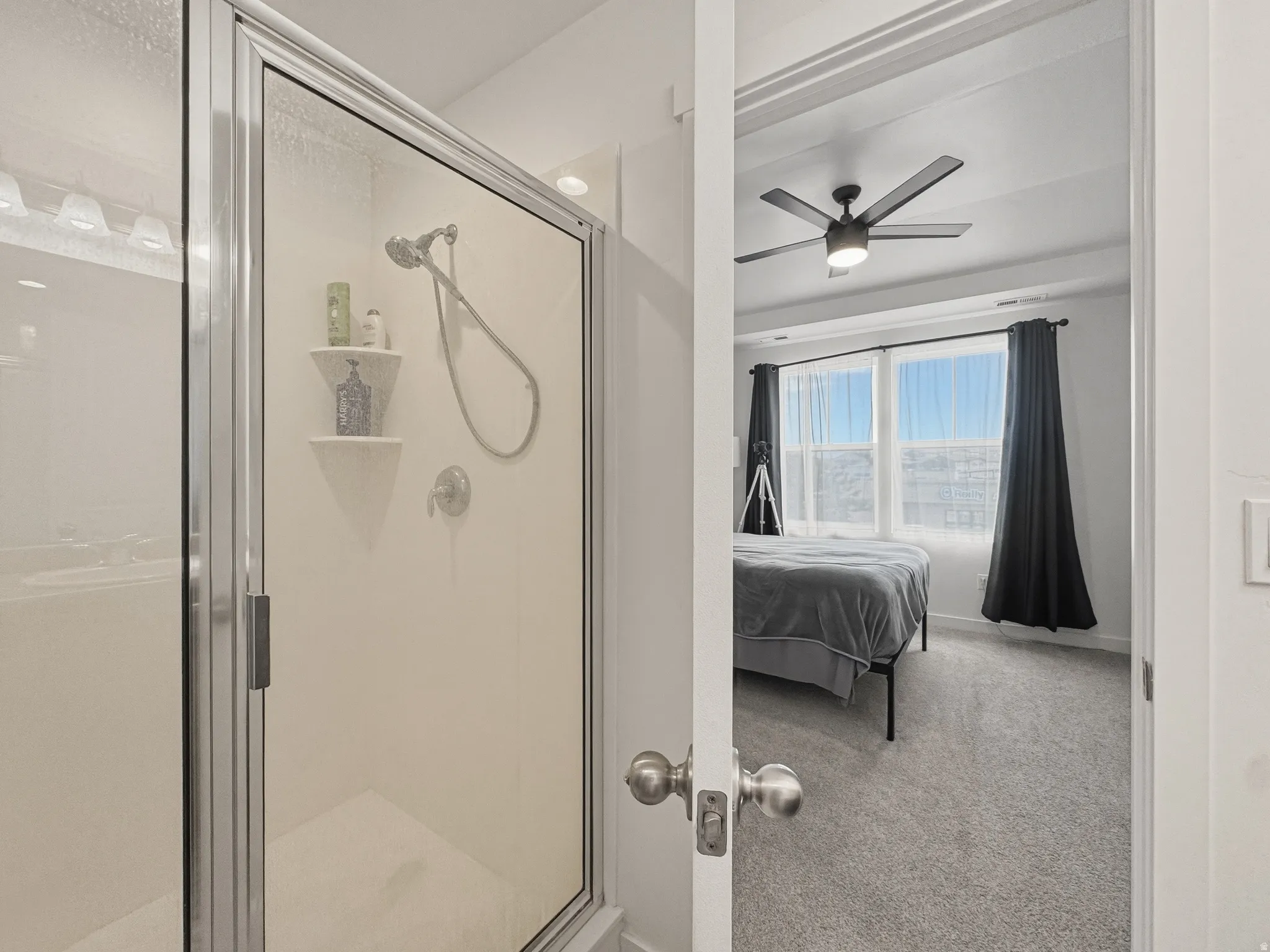 Glass-enclosed shower with chrome fixtures and built-in shelving
