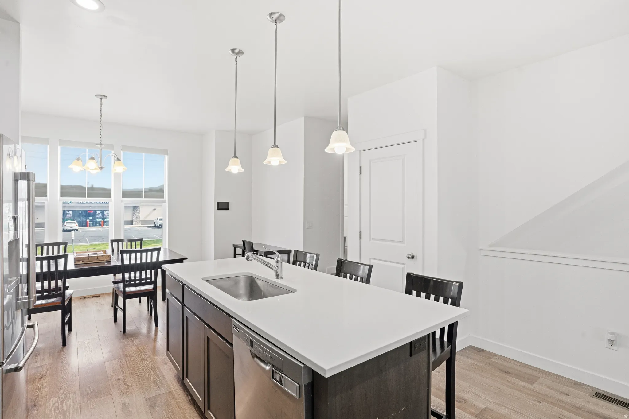 Contemporary kitchen island with an undermount sink, integrated dishwasher, and white countertop