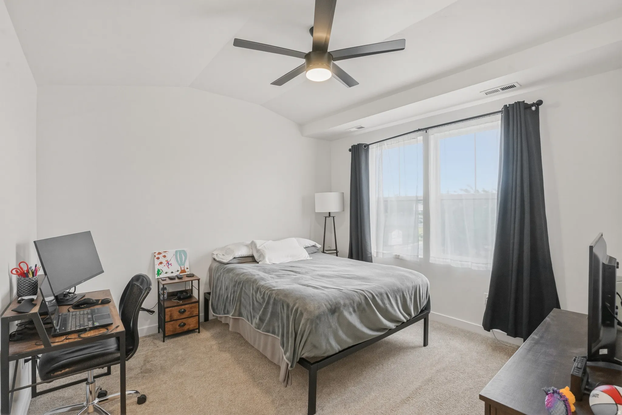 Spacious room with vaulted ceilings and neutral carpeting
