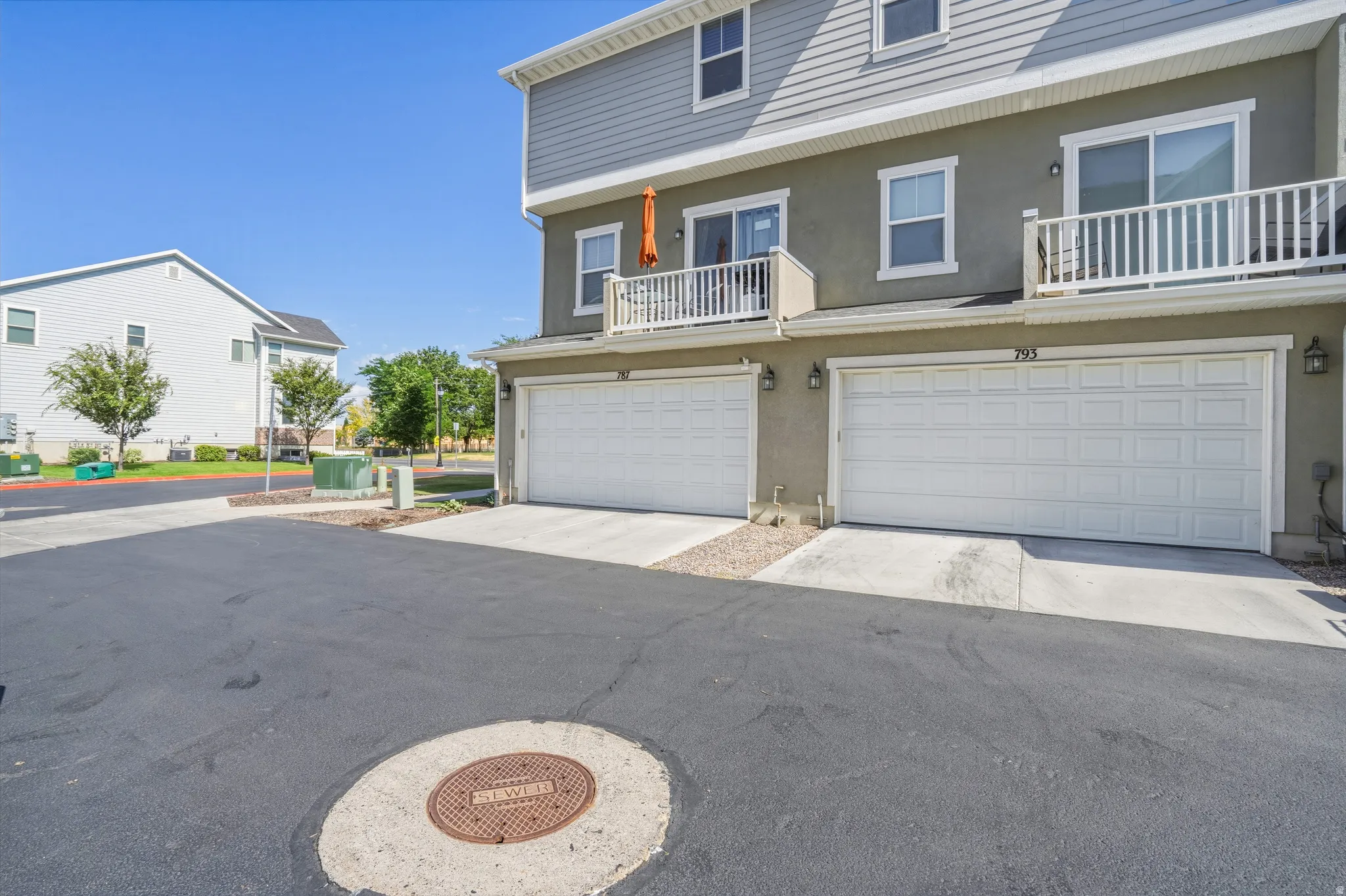 Contemporary townhome exterior featuring light gray siding and stucco finishes