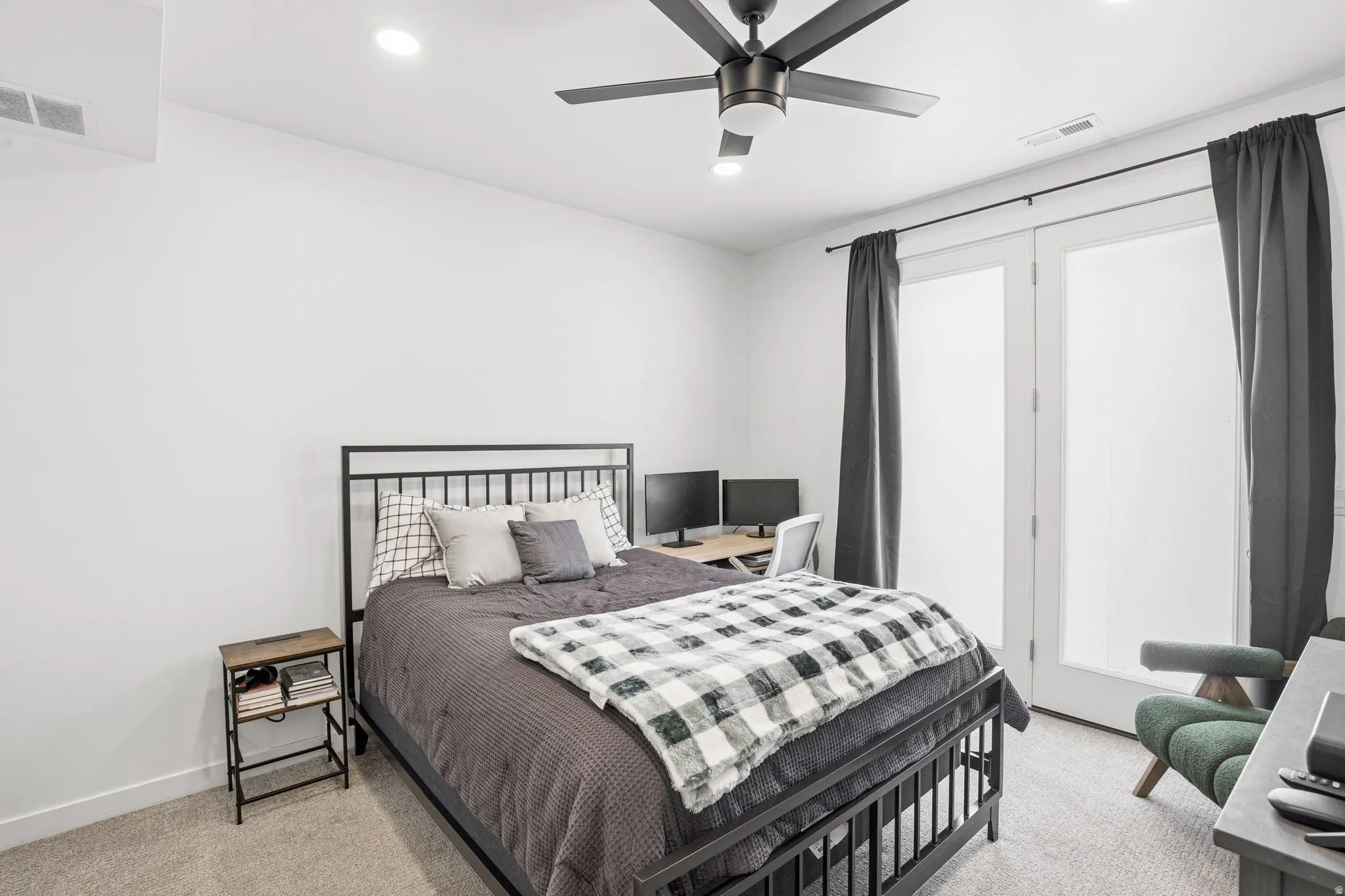 Spacious room featuring light-colored carpeting, a black ceiling fan with integrated lighting, recessed lighting, and white walls