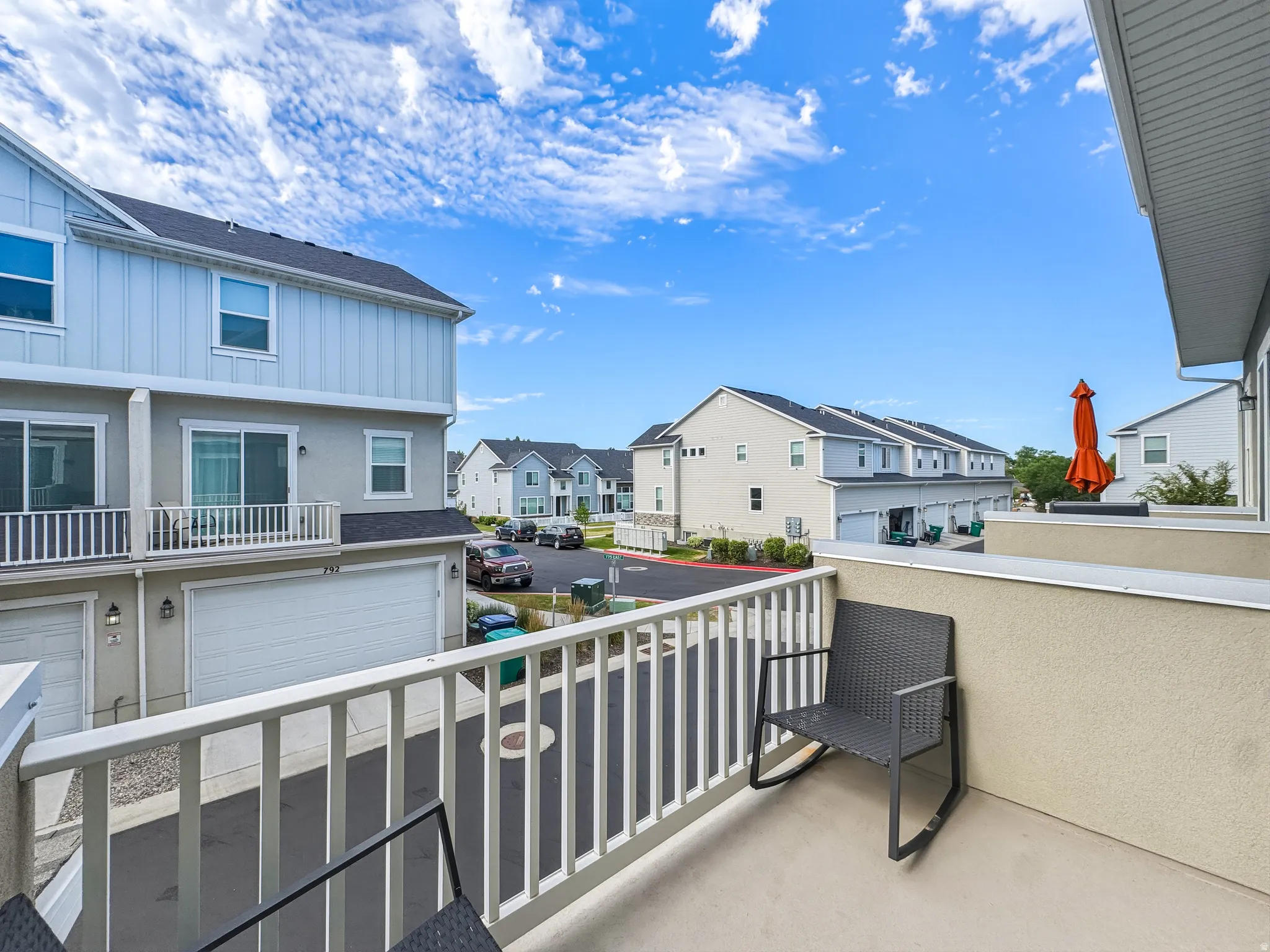 Private balcony featuring a stucco exterior wall and white railing