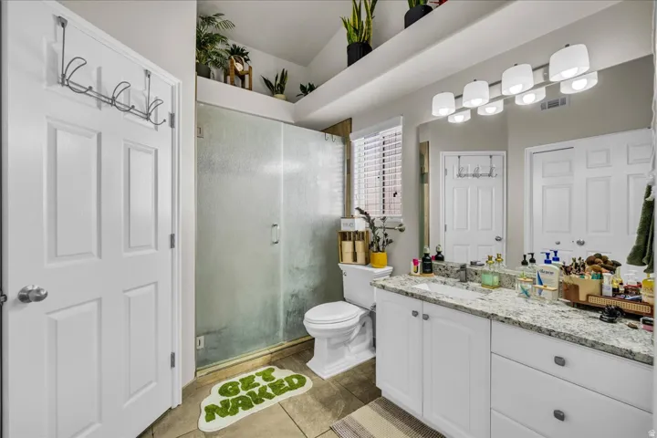Bathroom featuring a white vanity with a light-colored countertop, an integrated sink, and an expansive mirror
