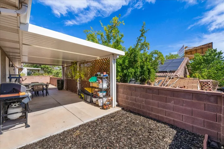 Covered patio featuring a solid roof structure and lattice wall accents