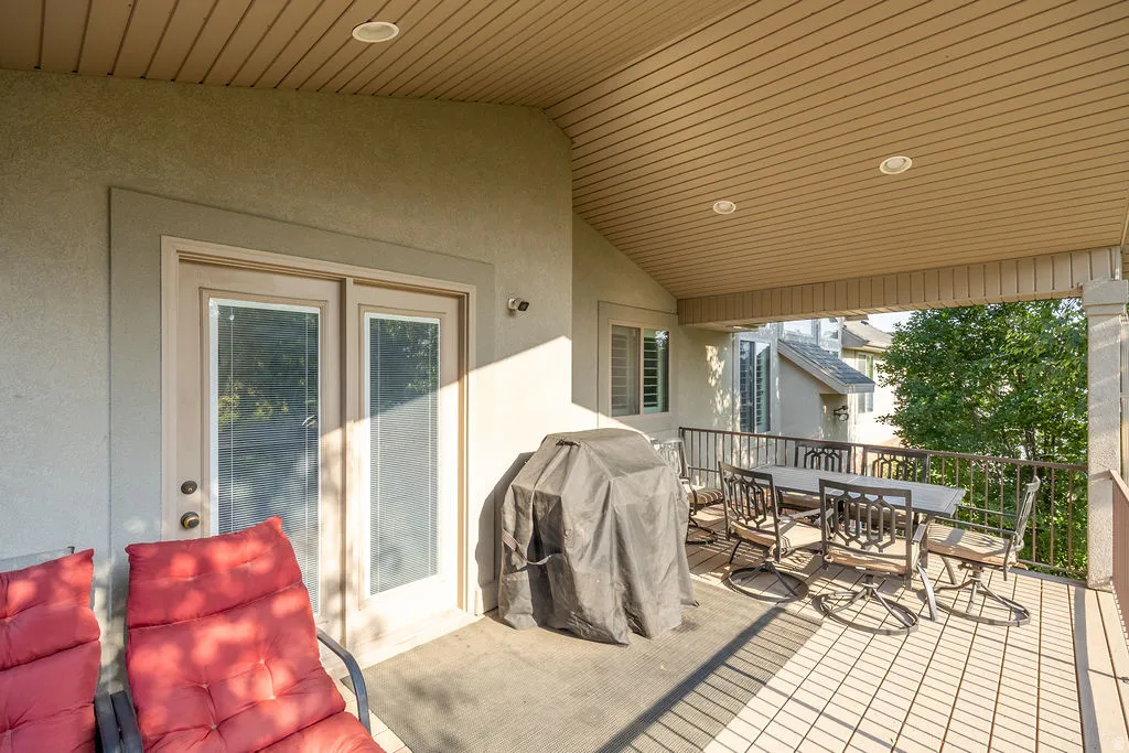 Covered outdoor patio featuring light-toned flooring, a protective railing, and recessed ceiling lighting