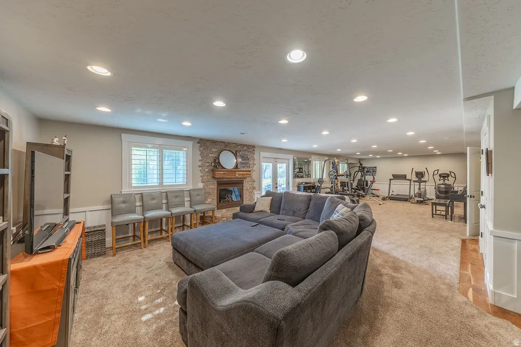 Spacious lower-level area with recessed lighting and neutral carpeting