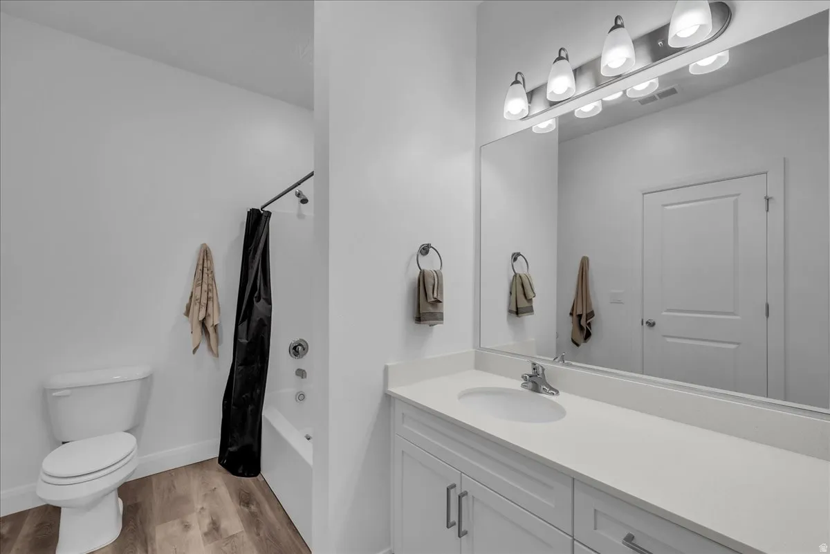 Bathroom featuring a single vanity with a white countertop, undermount sink, and chrome faucet