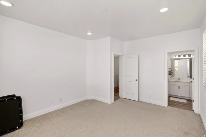 Carpeted room featuring recessed lighting and white baseboards