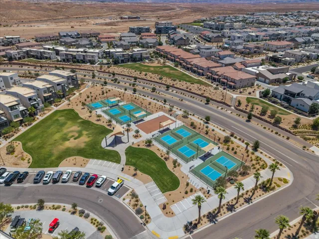 Community amenities featuring multiple sports courts, expansive green spaces, palm trees, and walking paths