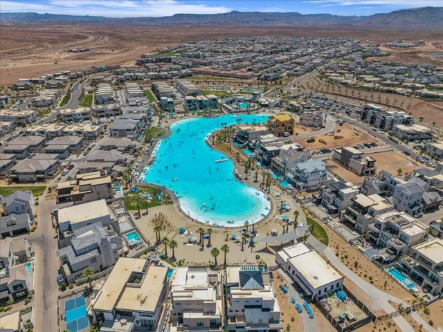 Expansive community featuring a large, blue-water lagoon surrounded by sandy shorelines and residential properties