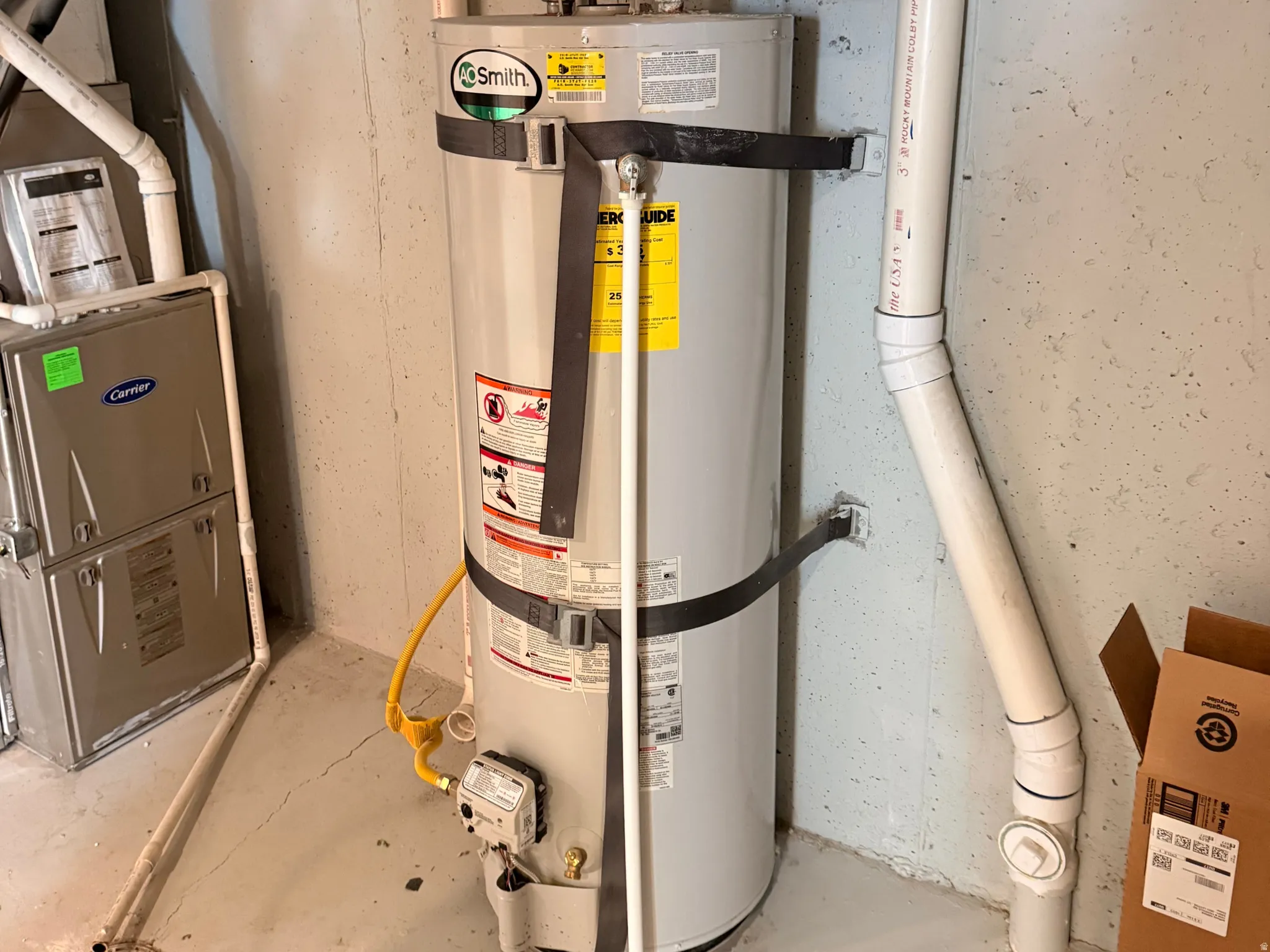 Water heater with expansion tank and adjacent utility pipes