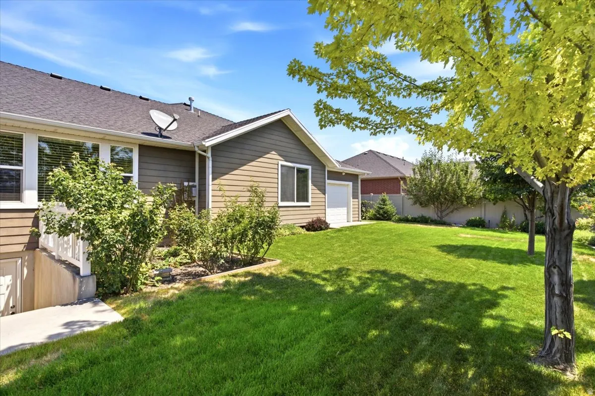 Expansive green lawn with mature trees and perimeter shrubbery