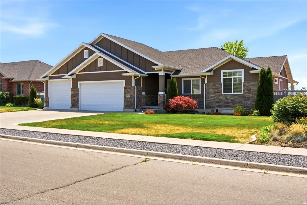 Front exterior featuring stone facade accents, dark siding, and white trim