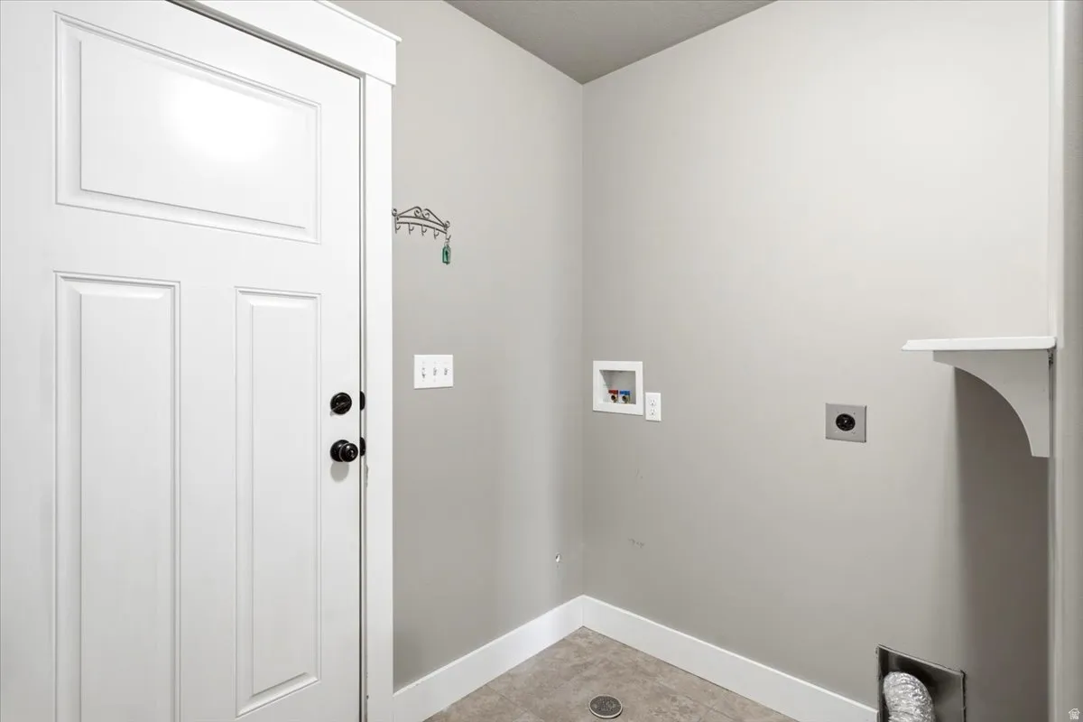 Dedicated laundry area featuring light gray walls and durable flooring