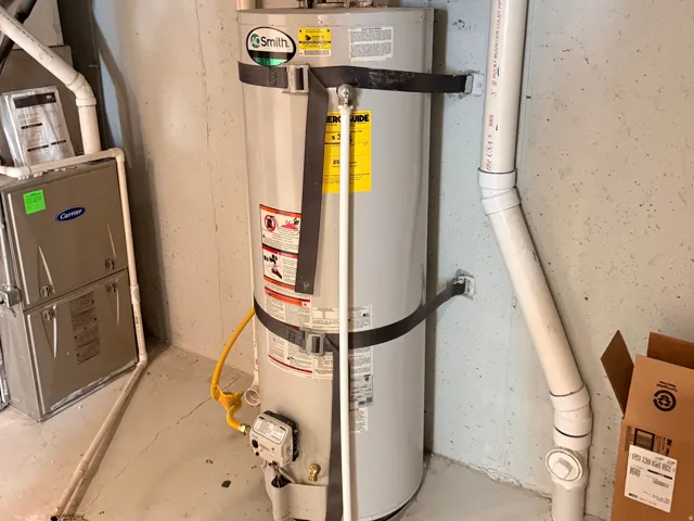 Water heater with expansion tank and adjacent utility pipes